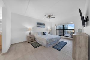 Un dormitorio blanco con una cama y un ventilador de techo. en Amazing 6th floor beachfront condo wonderful views, en South Padre Island 18 fotos más