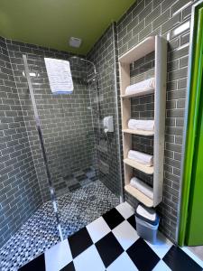 a bathroom with a shower and black and white tiles at Hôtel Restaurant Le Parc in Arc-en-Barrois