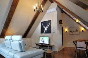 a living room with a white couch and a tv at Appartement Jacques Cartier in Saguenay