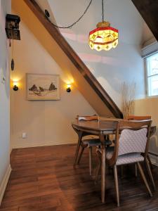 una sala da pranzo con tavolo in legno e lampadario pendente di Appartement Jacques Cartier a Saguenay