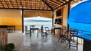 a restaurant with tables and chairs and a view of the water at Canto do lago pousada in Guapé