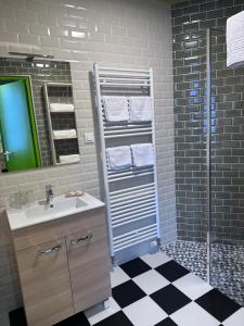 a bathroom with a sink and a shower at Hôtel Restaurant Le Parc in Arc-en-Barrois