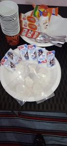 a white plate with food on top of a table at Sanjana Holiday Apartment in Varanasi