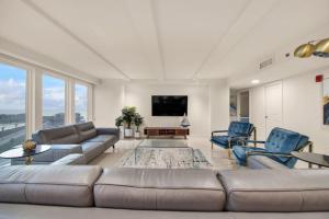 a living room with a couch and chairs and a tv at Luxury Beachfront Condo With Amazing Sunset Views in South Padre Island