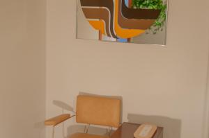 サグネにあるLa Maison Gagnonの椅子と壁画付きの部屋
