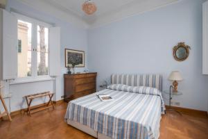 een slaapkamer met een bed met een gestreepte deken bij TRASTEVERE APARTMENT - ZEN REAL ESTATE SRL in Rome