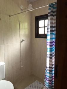 a bathroom with a shower with a colorful shower curtain at Recanto dos Pássaros em Petrópolis in Petrópolis