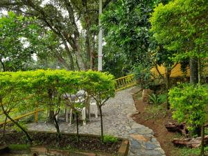 a stone path in a garden with trees and a fence at Apartamento Campestre Medellin in Medellín