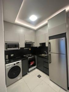 a kitchen with a stainless steel refrigerator and a stove at cozy home near all services (21) in Rujm ash Sharāʼirah