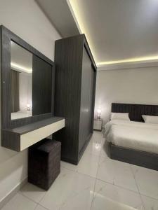 a bedroom with a bed and a dresser with a mirror at cozy home near all services (21) in Rujm ash Sharāʼirah