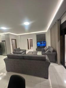 a living room with two couches and a tv at cozy home near all services (21) in Rujm ash Sharāʼirah