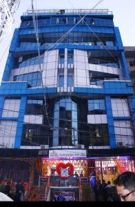 a tall blue building with people in front of it at Hotel Suryansh Pvt Ltd in Heṭauḍā