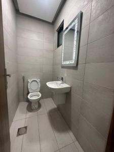 a bathroom with a toilet and a sink and a mirror at cozy home near all services (21) in Rujm ash Sharāʼirah