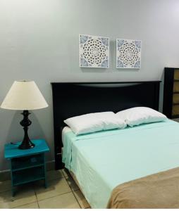 1 dormitorio con 1 cama y 1 mesa con lámpara en Pedregal Suites - Marina and Downtown en Cabo San Lucas