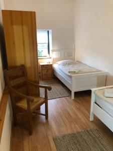 a bedroom with a bed and a chair and a window at Das Abendrote Haus in Gömnitz