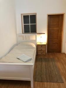 Schlafzimmer mit einem weißen Bett und Holzboden in der Unterkunft Das Abendrote Haus in Gömnitz