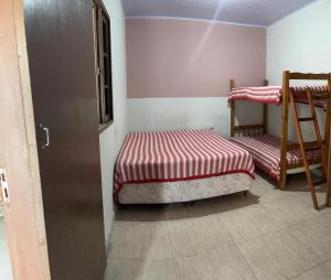 1 Schlafzimmer mit 2 Etagenbetten und einer Leiter in der Unterkunft Kitnet em Cabo Frio 04 in Cabo Frio