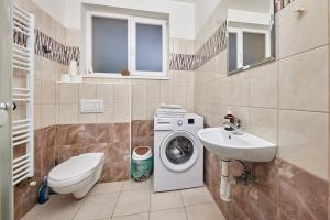 a bathroom with a washing machine and a sink at Sweet apartment in Bratislava