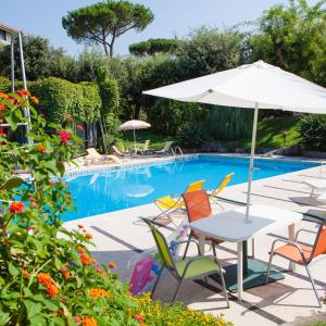 a table with an umbrella next to a swimming pool at B&B Casina de Goyzueta in Torre del Greco