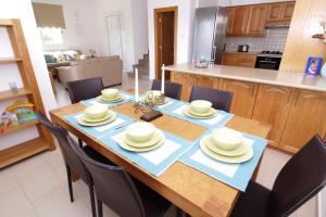 a dining room table with chairs and a kitchen at Maouris Villa in Protaras
