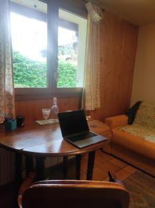 un ordenador portátil sobre una mesa en una habitación con ventana en TellaHouse en Chamonix-Mont-Blanc