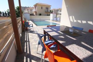 a patio with a table and chairs and a swimming pool at Maouris Villa in Protaras