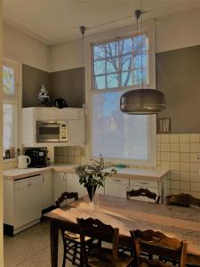 een keuken met een houten tafel en een raam bij Bed and Breakfast Juliana in Eindhoven