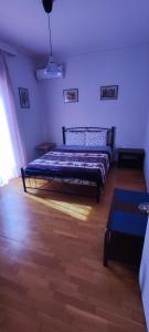Schlafzimmer mit einem Bett und Holzboden in der Unterkunft Quiet - Comfortable apartment 33sqm Pagrati Athens in Athen