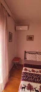 1 dormitorio con cama, mesa y ventana en Quiet - Comfortable apartment 33sqm Pagrati Athens, en Atenas