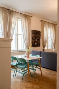 Frida Apartman في براتيسلافا: غرفة معيشة مع طاولة وكراسي وعلى الحائط