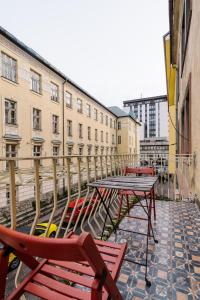 un groupe de tables et de chaises sur une terrasse avec des bâtiments dans l'établissement Frida Apartman, à Bratislava