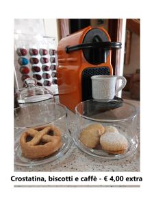 - deux plats de beignets en verre sur un comptoir avec une cafetière dans l'établissement Affittacamere Is Coronas, à Ìsili