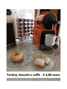 a counter with a coffee maker and some donuts at Affittacamere Is Coronas in Ìsili