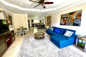 a living room with a blue couch and a table at Spacious Penthouse with pool & Jungle Views in La Mona