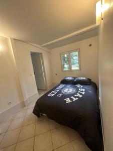 um quarto com uma cama preta num quarto em PrJARDIN em Le Blanc-Mesnil