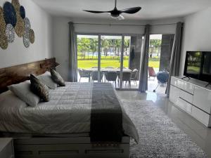 a bedroom with a bed and a television and a table at MAREAZUL Beachfront Apartment 2BR Private Pool Casa Áncora in Playa del Carmen