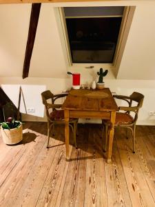 einen Holztisch und Stühle in einem Zimmer mit Fenster in der Unterkunft Mihr's rustplek in de Abdij van Bornem in Bornem