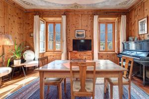 una sala da pranzo con tavolo e pianoforte di Casa Pool tra St Moritz e il lago di Como a Castasegna