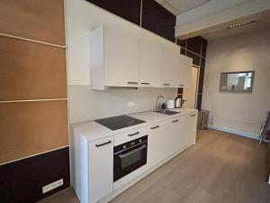 a kitchen with white cabinets and a sink at Cozy independent Studio S2, City Centre Dordrecht in Dordrecht