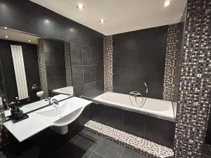 a bathroom with a bath tub and a sink at Cozy Studio S2, City Centre Dordrecht in Dordrecht