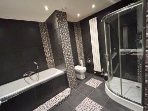 uma casa de banho com um chuveiro, uma banheira e um WC. em Cozy Studio S2, City Centre Dordrecht em Dordrecht