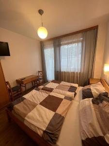 a bedroom with two beds and a table and a window at Pension Strasser in Bad Schallerbach