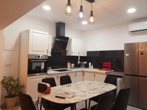 uma cozinha com uma mesa com cadeiras e um frigorífico em Mar y Sol Suites em Grao de Castellón