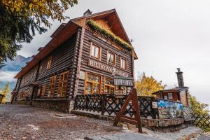 a wooden building with a sign in front of it at BILÍKOVA CHATA - Horský hotel in Vysoke Tatry - Stary Smokovec