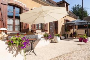 patio ze stołem i parasolem w obiekcie Le Sarcinoé w mieście Sergines