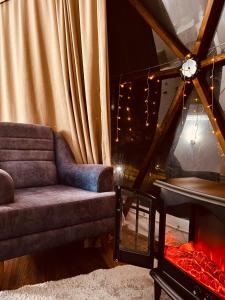 a living room with a couch and a fireplace at Phalesia Glamping Otel in Sapanca