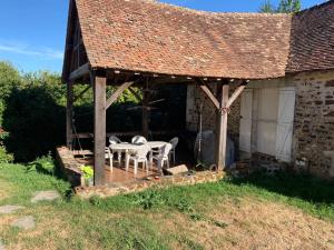 CoulongéPetit Moulin Renaissance的房屋前设有带桌椅的凉亭