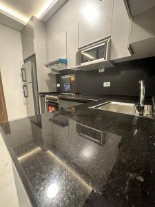 a kitchen with a black counter top at cozy home near all services (19) in Rujm ash Sharāʼirah
