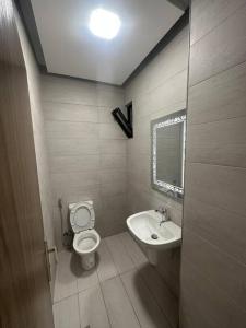 małą łazienkę z toaletą i umywalką w obiekcie cozy home near all services (19) w mieście Rujm ash Sharāʼirah