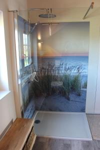 a bathroom with a shower with a mural of the ocean at Idyllisches-Blockbohlenhaus-mit-eigenem-Garten-und-Sauna-zum-Wohlfuehlen in Martensrade